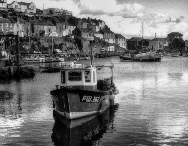 black and white boat in Mevagissey harbour Cornwall